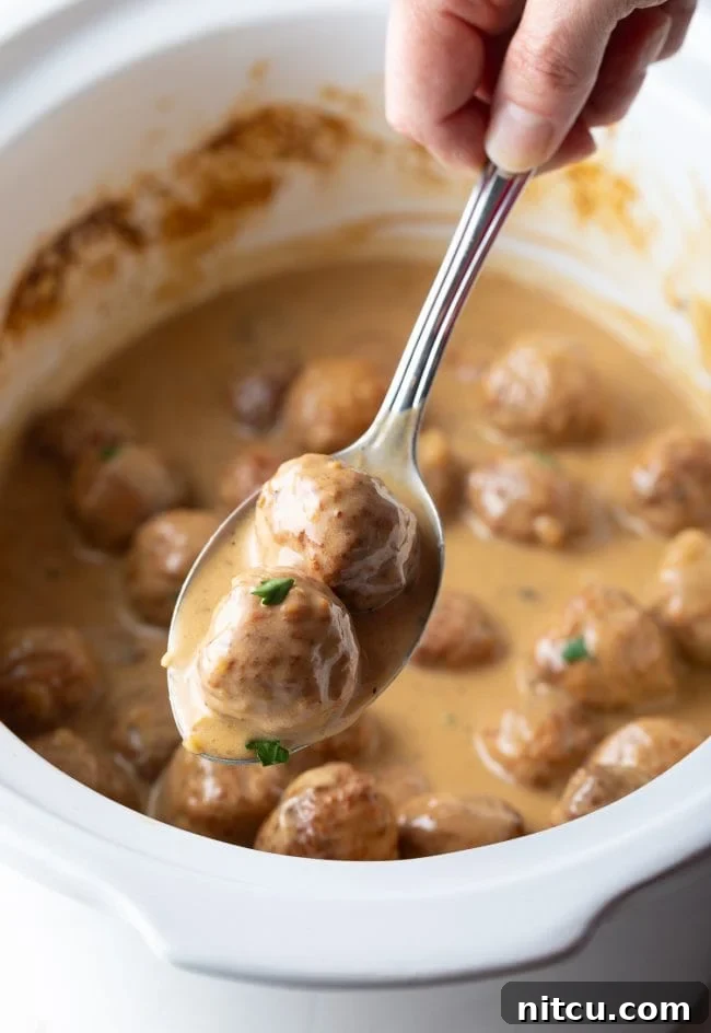 Effortless Slow Cooker Swedish Meatballs 2 Creamy Swedish Meatballs cooked in a slow cooker, ready to serve over mashed potatoes.