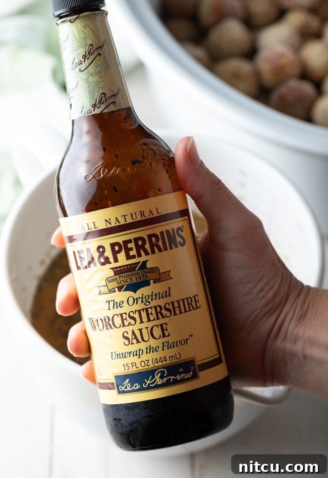 Effortless Slow Cooker Swedish Meatballs 5 A bottle of Worcestershire sauce, a key ingredient for authentic Swedish Meatball flavor, displayed on a wooden surface.