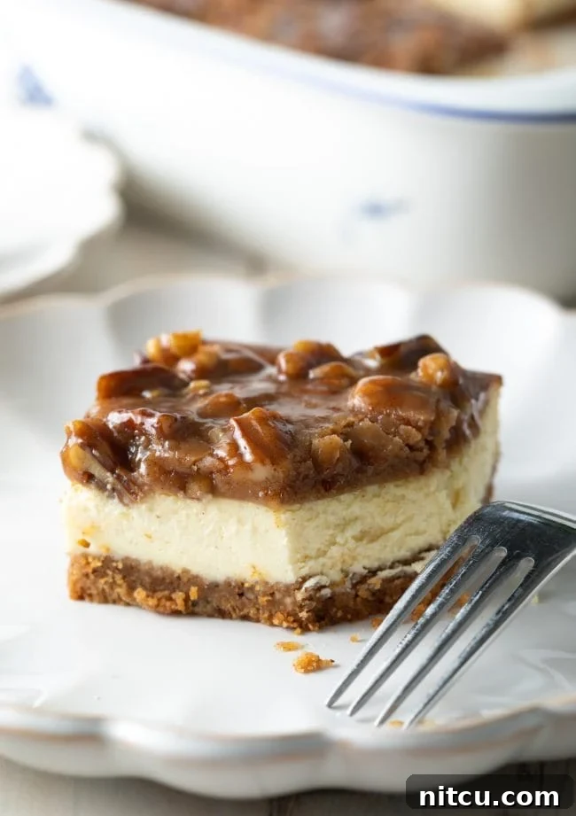 Pecan Praline Cheesecake Delight 4 A pecan pie cheesecake bar on a plate with a fork, showing a bite removed to highlight the creamy texture and rich topping.