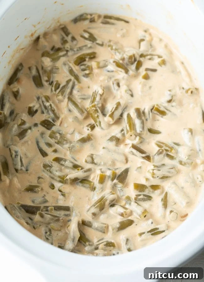 Ultimate Cream Cheese Slow Cooker Green Bean Casserole 6 Crockpot Green Bean Casserole with cream cheese bubbling gently in the slow cooker, perfectly cooked and ready for its final topping.