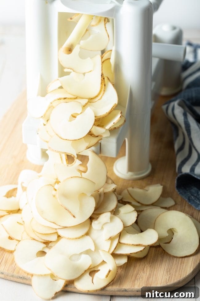 Using a spiralizer to cut thin pieces of potatoes.