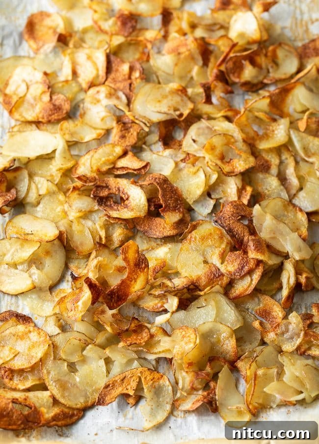 Crunchy oven roasted potato ribbons on parchment paper.