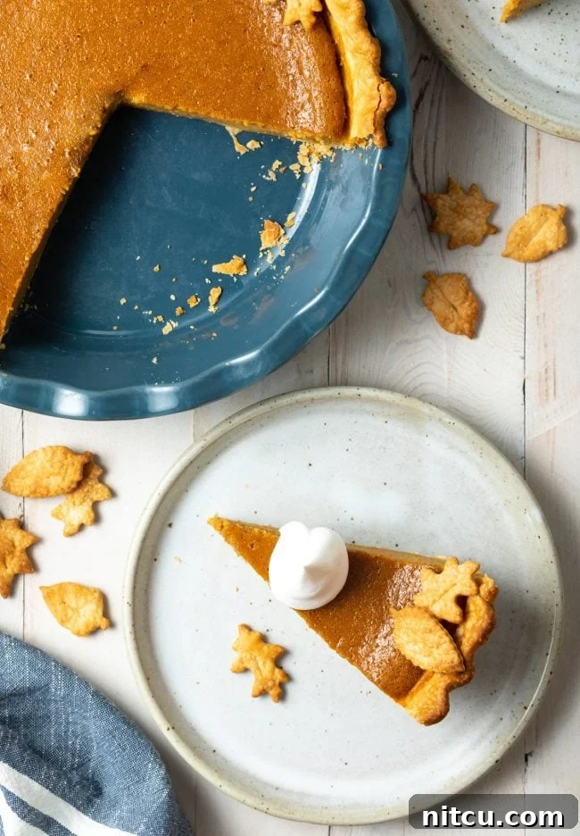 Libbys Classic Pumpkin Pie 13 Overhead shot of pumpkin pie slice on a plate next to the rest of the pie.