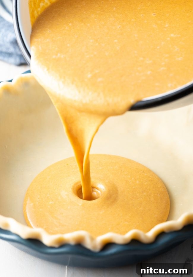 Libbys Classic Pumpkin Pie 8 Pouring the pumpkin pie mixture into a pie crust lined pie pan.