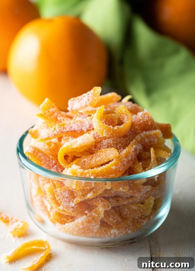 Orange Peel Confections 3 Small glass bowl filled with radiant candied orange peels, ready to be enjoyed or used as a festive garnish.