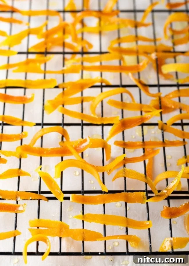 Orange Peel Confections 6 Freshly candied orange peels laid out on a drying rack, allowing excess syrup to drain and setting their sugary coating.
