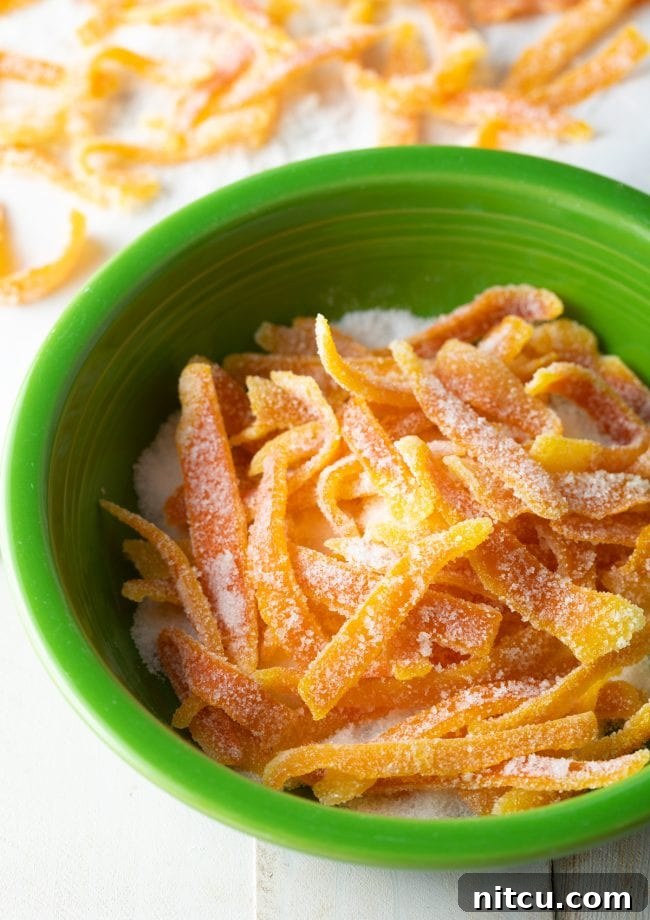 Orange Peel Confections 7 A bowl of granulated sugar ready for coating vibrant orange rinds, a crucial step in making the easiest candied orange peel.