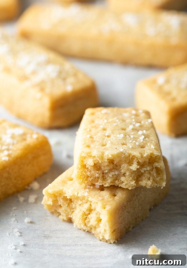 Buttery Scottish Shortbread Delight 2 Scottish Shortbread Recipe - Two shortbread cookies broken in half and stacked on top of each other.