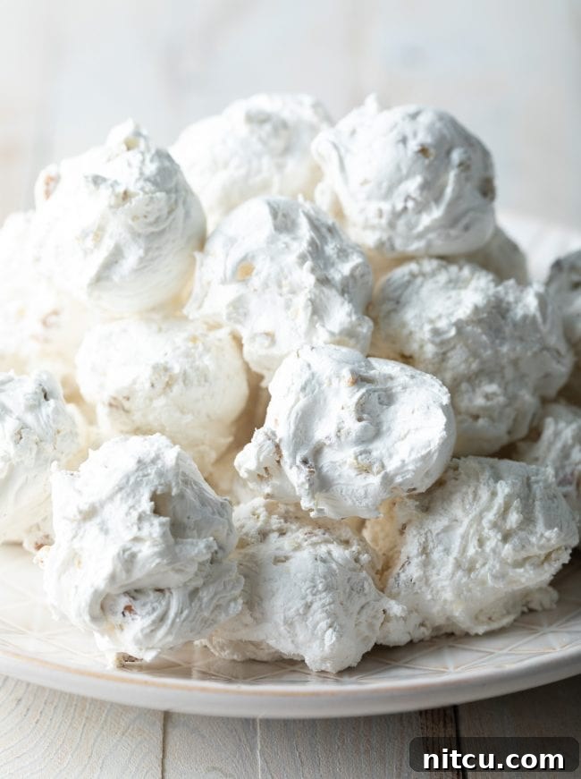 Divine Cloud Candy Delights 8 Fluffy pecan and nougat divinity candy piled up on a plate.