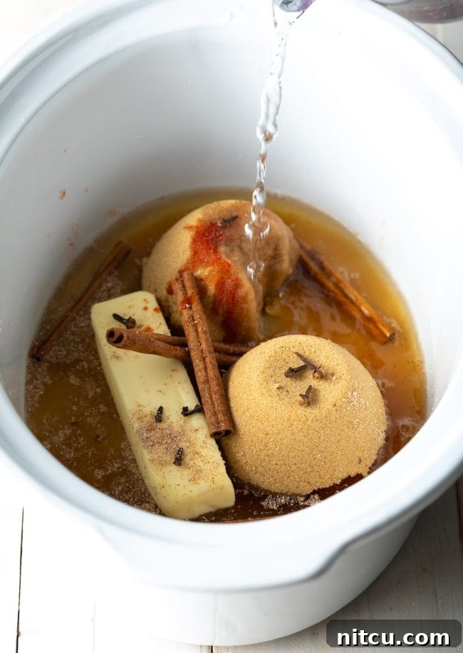 A collection of aromatic spices including cinnamon sticks, whole cloves, and nutmeg for Hot Buttered Rum