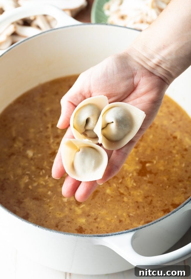 Ultimate Wor Wonton Soup 12 Delicate wontons being carefully added to the simmering soup base in a pot.