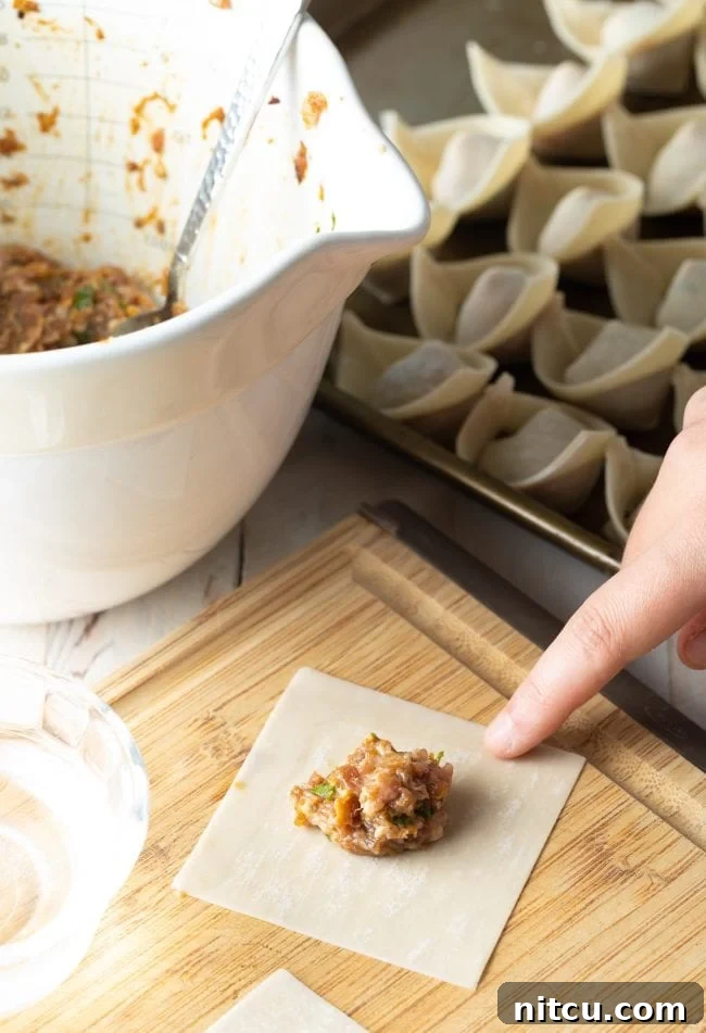 Ultimate Wor Wonton Soup 6 Homemade wonton filling meticulously placed on a wonton wrapper, ready for folding.