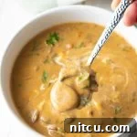Classic Hungarian Mushroom Soup Made Vegan and Gluten Free 13 A bowl of creamy Hungarian Mushroom Soup with a swirl of sour cream and fresh dill garnish.