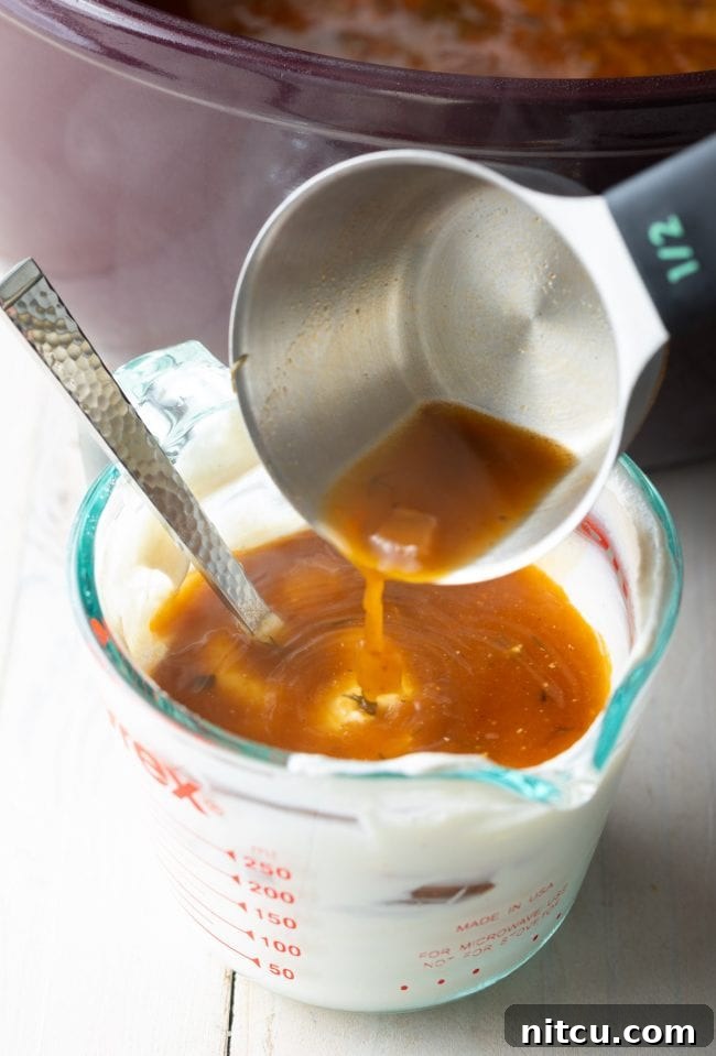 Classic Hungarian Mushroom Soup Made Vegan and Gluten Free 8 Mixing hot soup broth into a bowl of cashew cream to temper it for a vegan soup base.