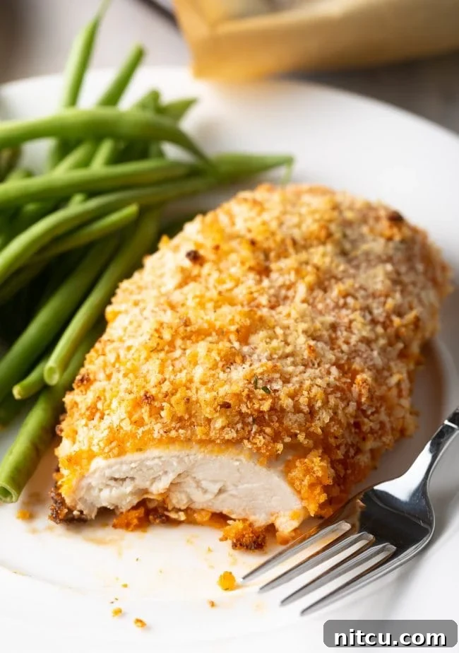 Close-up view of a perfectly cooked, crispy buffalo chicken breast, sliced to reveal its juicy interior.