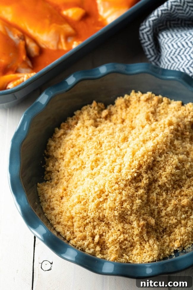 Panko breadcrumbs mixed with ranch seasoning in a pie pan, forming the perfect coating for the chicken.