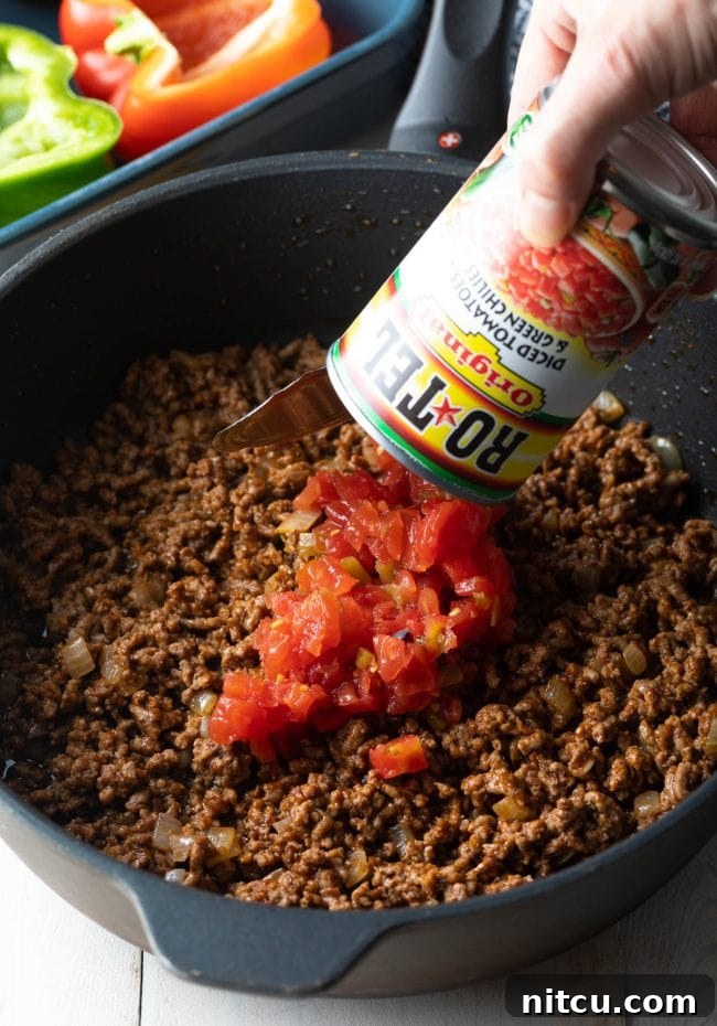 Savory Keto Bell Pepper Boats 5 rotel and ground beef in pan for stuffed pepper filling