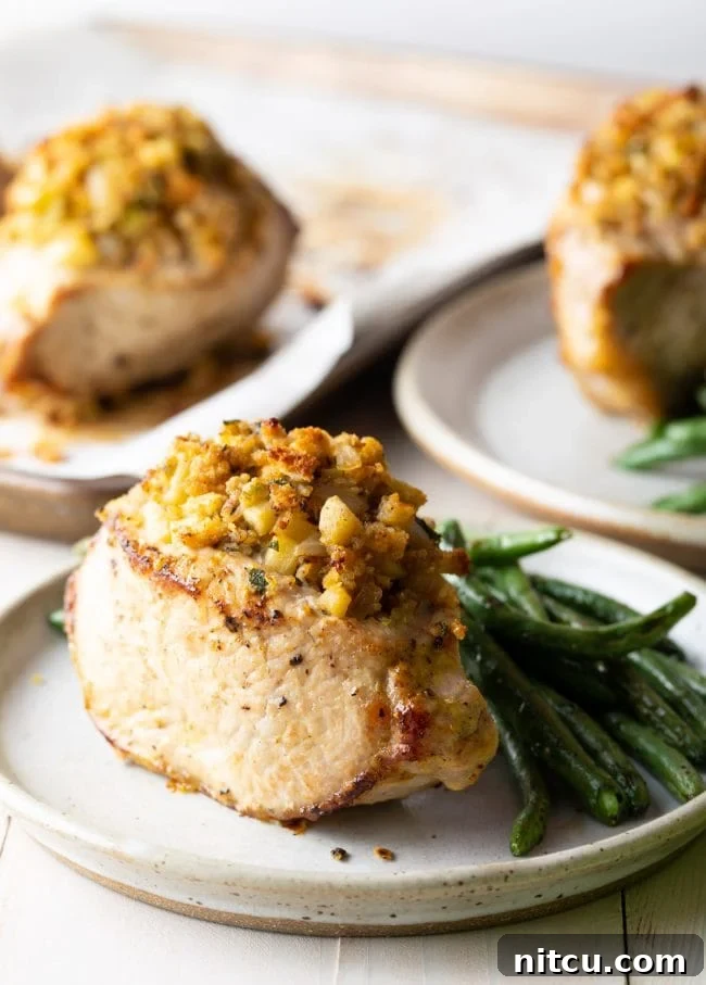 Tender Apple-Stuffed Baked Pork Chops 2 Side view of 3 plates with apple stuffed pork and green beans as a side dish