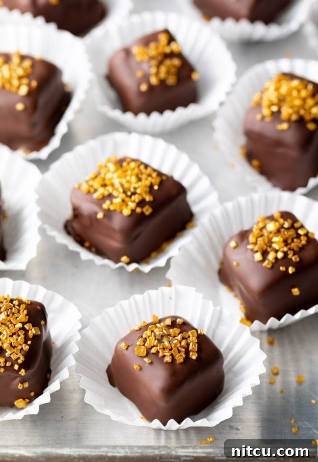 Mini chocolate cakes with shimmering gold sprinkles on top, beautifully arranged. These are perfect homemade Petit Fours.