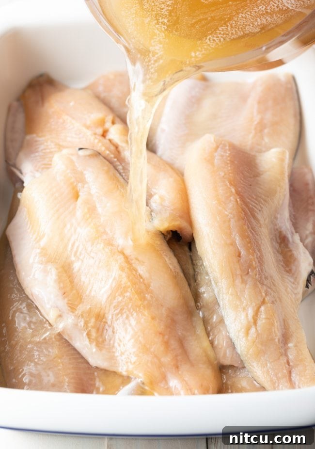 Fresh trout fillets being submerged in a homemade brine solution.