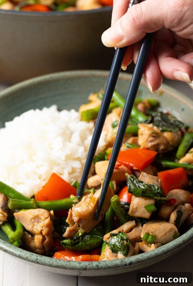 A bowl of Pad Krapow Gai with chopsticks, ready to be enjoyed.