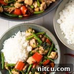 Close-up of a serving of Spicy Thai Basil Chicken, garnished with fresh basil.