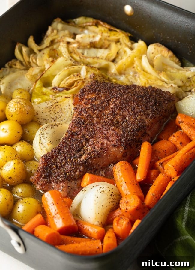 Corned beef, cabbage, potatoes, carrots and onions all roasted in a roasting pan. 
