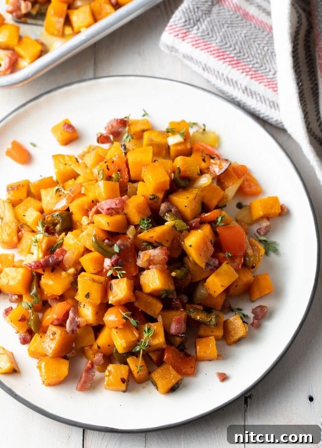 Sweet Potato and Bell Pepper Hash 3 A top-down view of a white plate generously filled with golden-brown sweet potato hash, artfully arranged for serving.