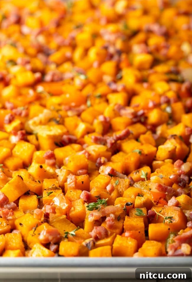 Sweet Potato and Bell Pepper Hash 7 A close-up view of golden-brown sweet potato hash browns on a baking sheet, showcasing their crispy texture and the colorful mix of ingredients.