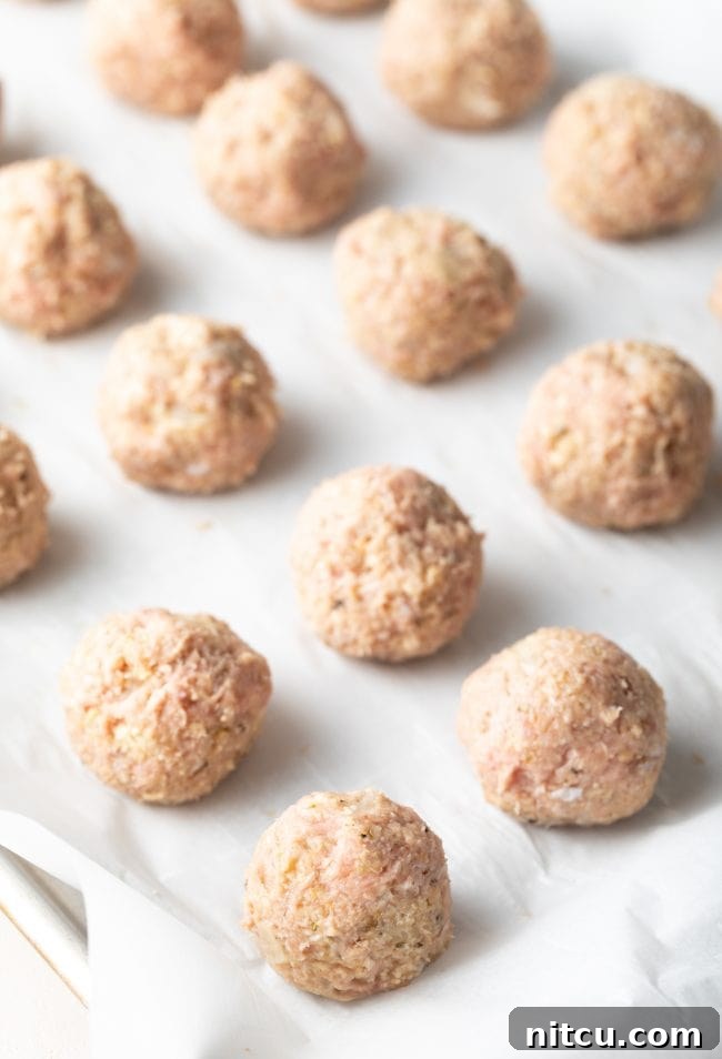 meatballs rolled onto baking sheets