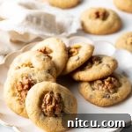 Chocolate chip walnut cookies lined up in a circle on a white plate.
