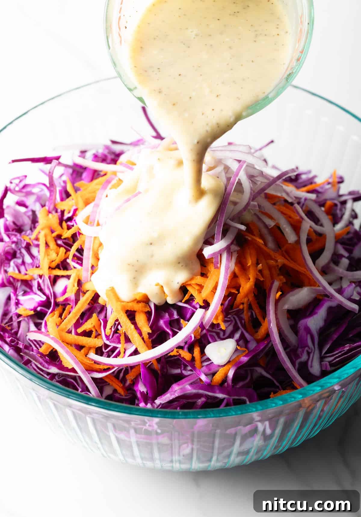 Crimson Cabbage Crunch 7 A mayonnaise mixture is being poured over a red cabbage slaw recipe.
