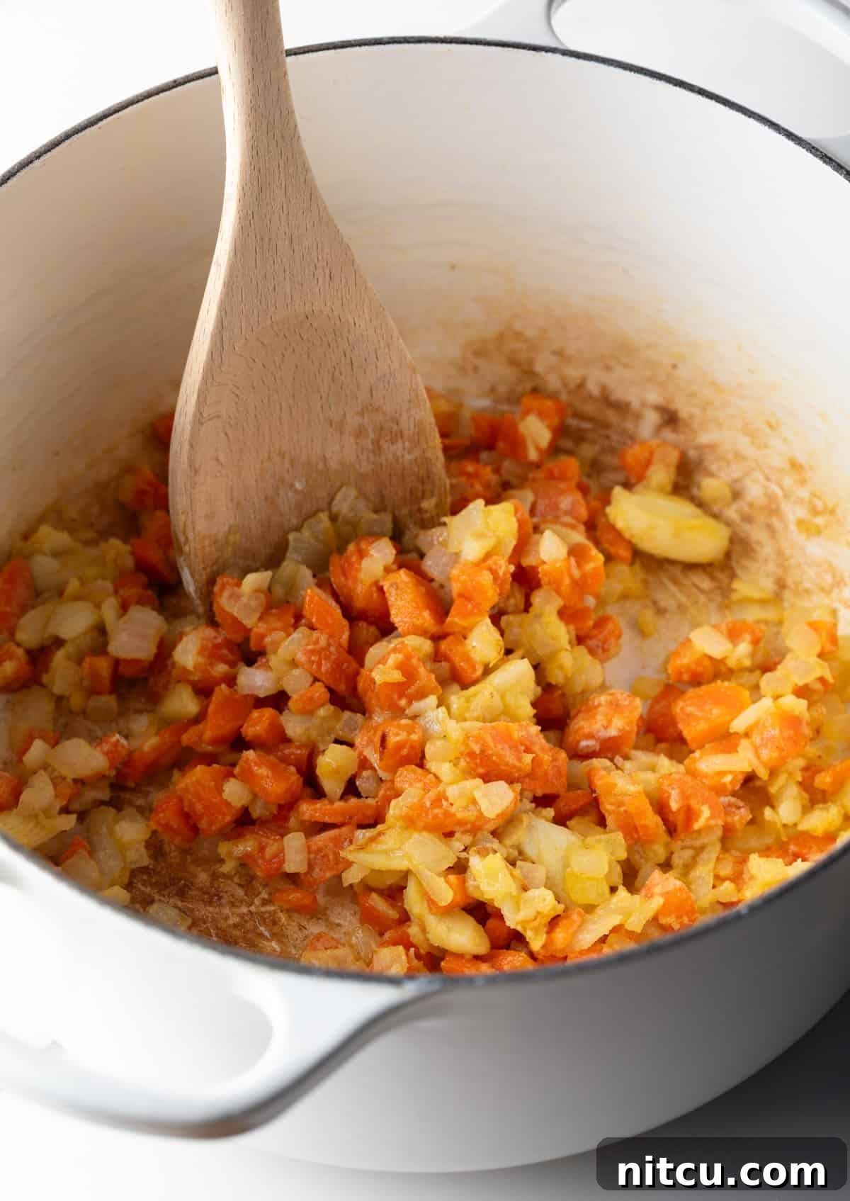 Decadent Crab Bisque 6 Flour is being stirred into the sautéed veggie mixture.